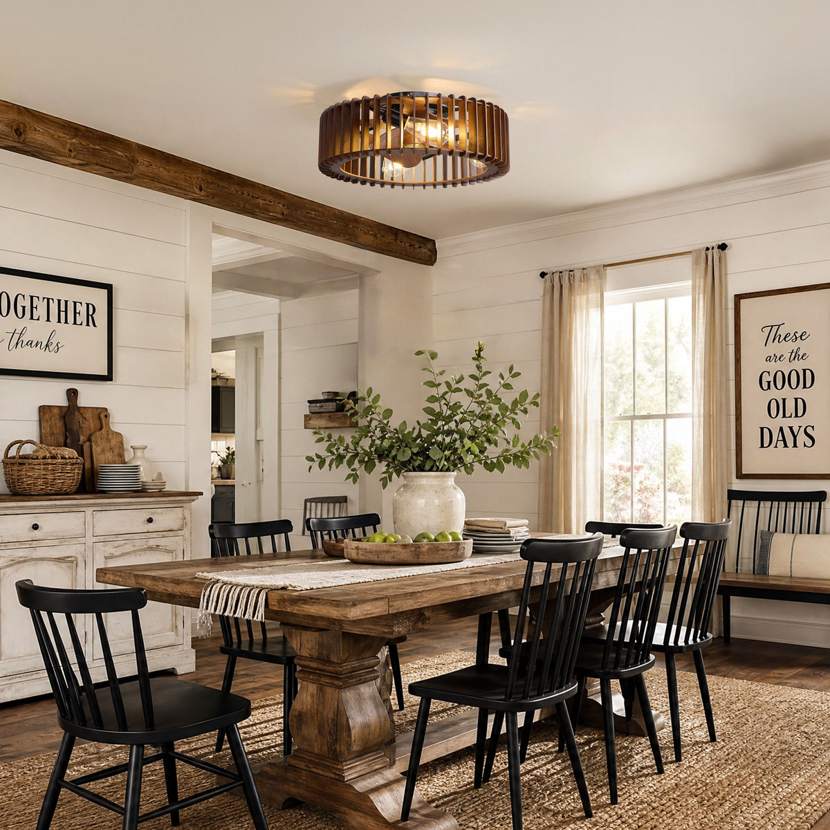 Industrial caged ceiling fan in farmhouse dining room — thick wood table, black Windsor chairs, decorative signs on shiplap walls, wood beam ceiling, warm Edison bulb glow | Sofary Lighting