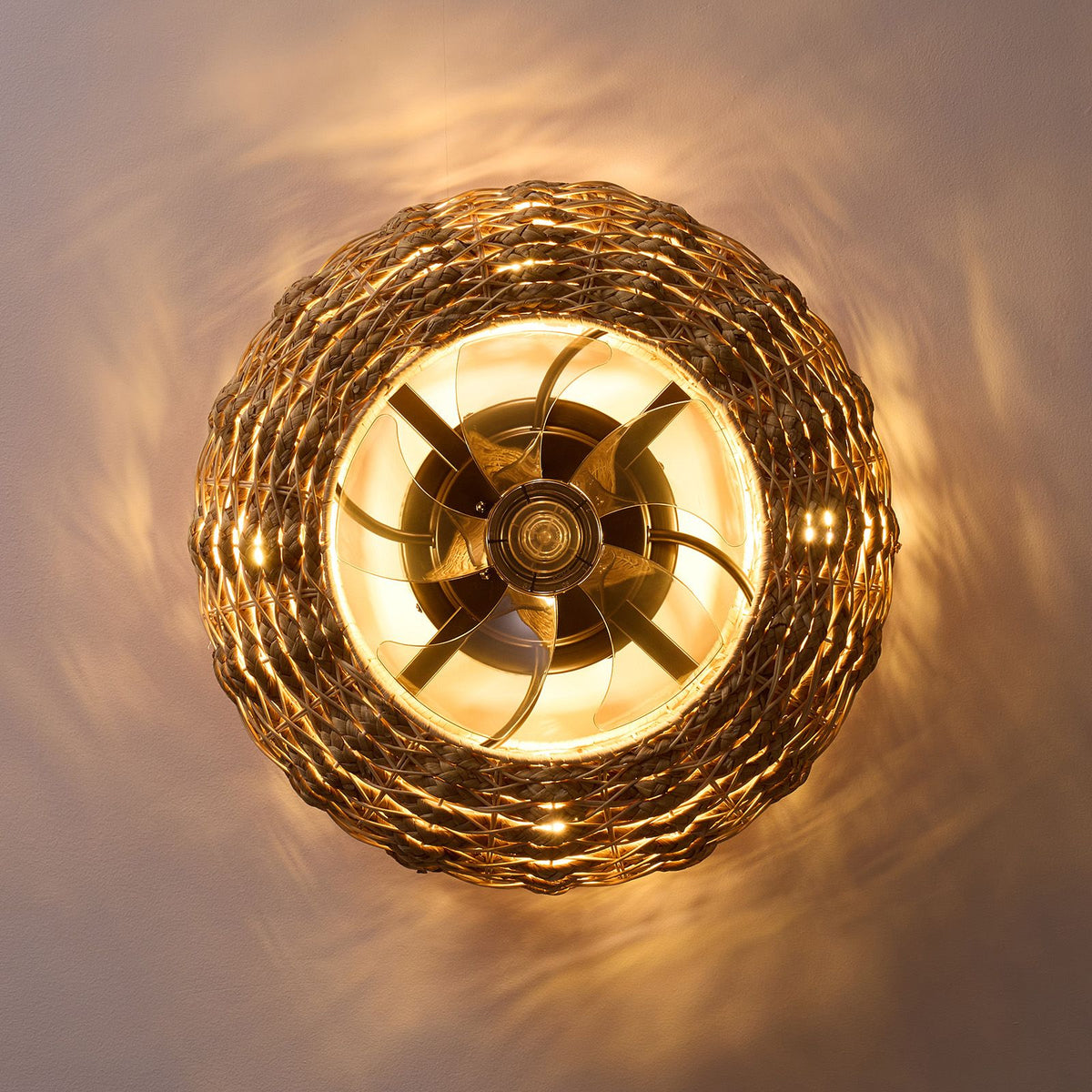 Bottom view of boho rattan ceiling fan in operation — spinning blades, warm LED ring, woven shade shadow on ceiling, flush mount fan light ambiance | Sofary Lighting