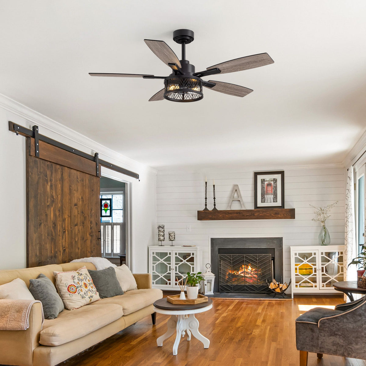 Farmhouse ceiling fan in rustic living room — sliding barn door, shiplap walls, fireplace, beige sofa, wood flooring, cozy farmhouse decor | Sofary Lighting