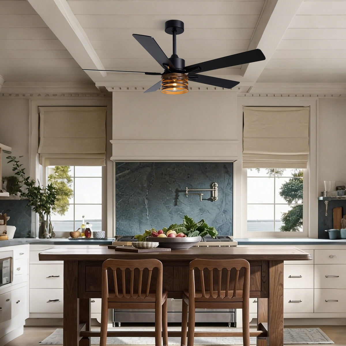 Industrial farmhouse ceiling fan over kitchen island — white cabinets, dark countertop, wood stools, windows with garden view, fruit bowl on counter | Sofary Lighting