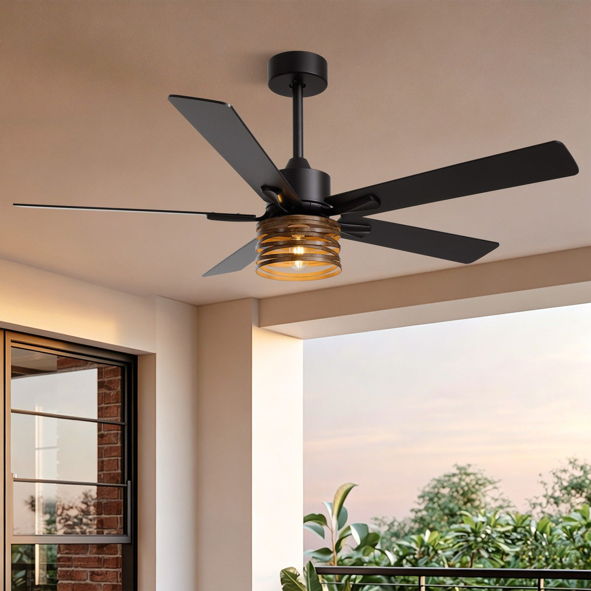 52" Industrial Farmhouse Ceiling Fan with Light — matte black motor, wood grain blades, amber ribbed glass light shade, mounted on patio ceiling with brick wall and garden view | Sofary Lighting
