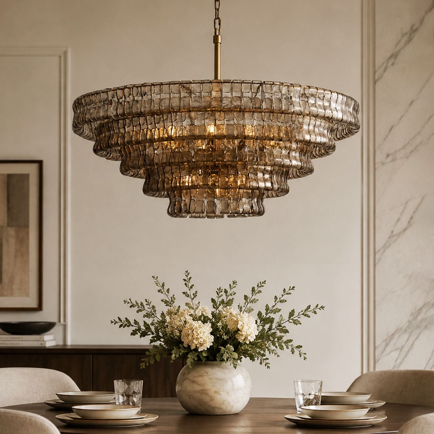 Aerore modern gold glass chandelier with textured, layered glass shades and warm brass finish, illuminating a bright, airy dining room with large windows and green views | Sofary Lighting