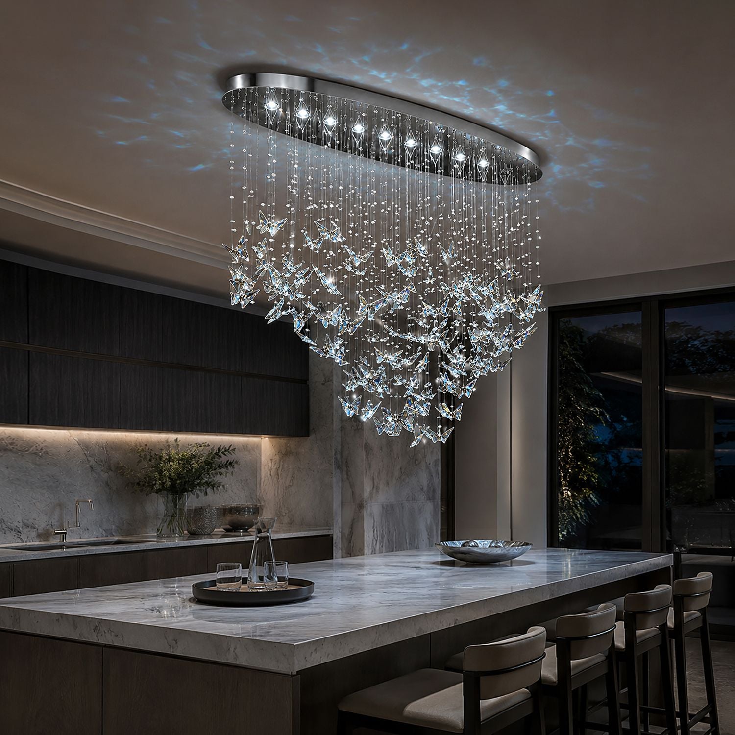 Aerosi Linear Chandelier over modern kitchen island — bar stools, marble countertop, dark cabinetry, warm ambient glow for culinary spaces | Sofary Lighting