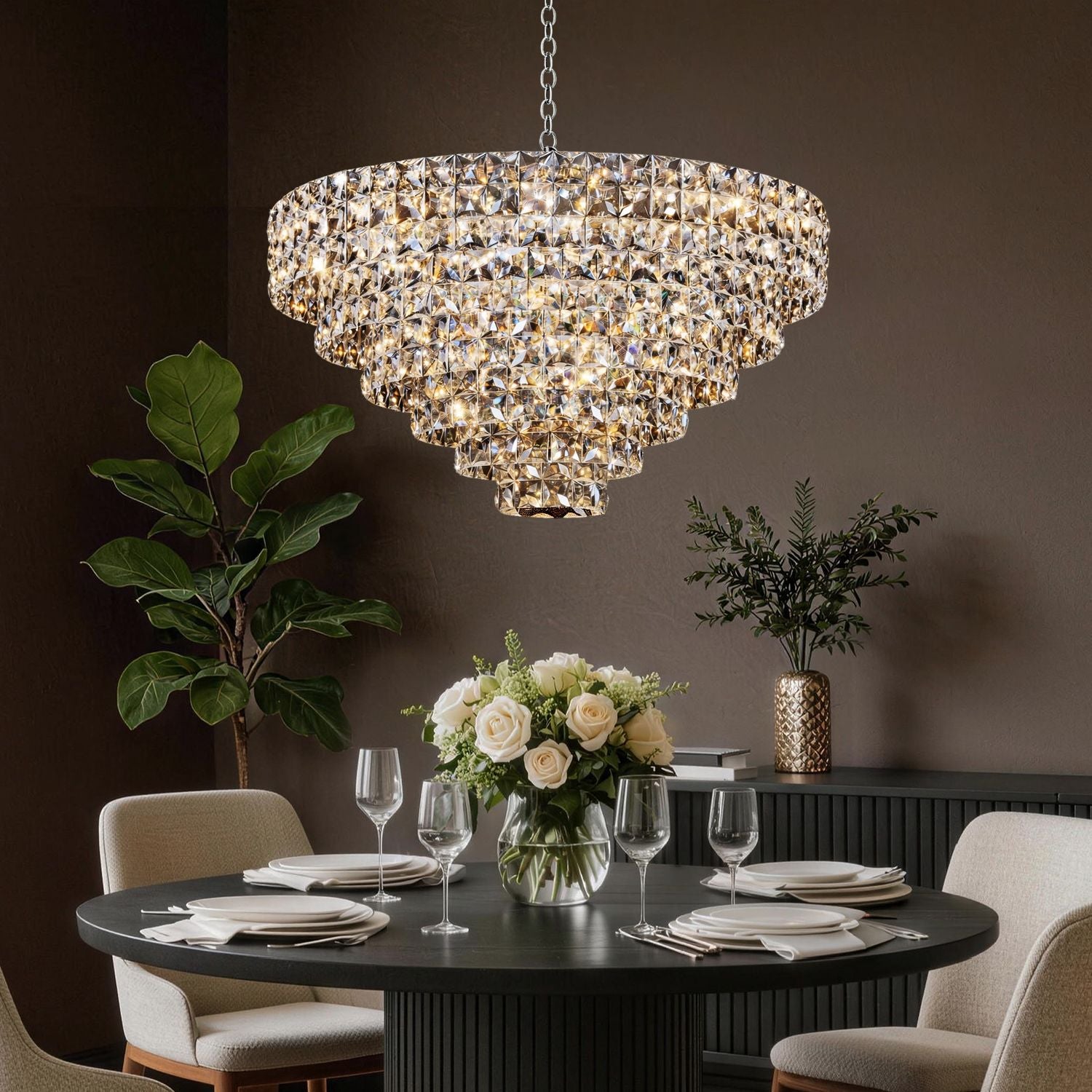 Aria Modern Gold K9 Crystal Glacier Chandelier in a sophisticated dining room — glowing warmly above a round wooden table, velvet chairs, and white floral centerpiece for elegant dinner parties | Sofary Lighting