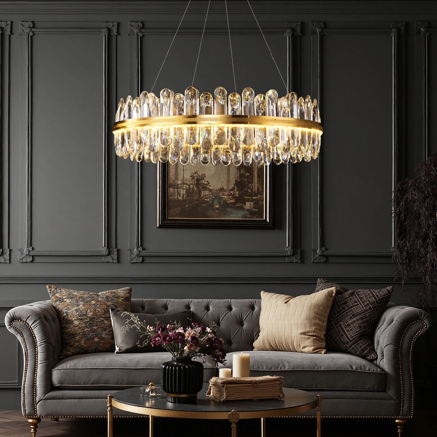 Aurelia Modern Luxury Champagne Gold K9 Crystal Chandelier in a living room — hanging above a tufted gray sofa with decorative pillows, dark wood paneling, and elegant accents | Sofary Lighting