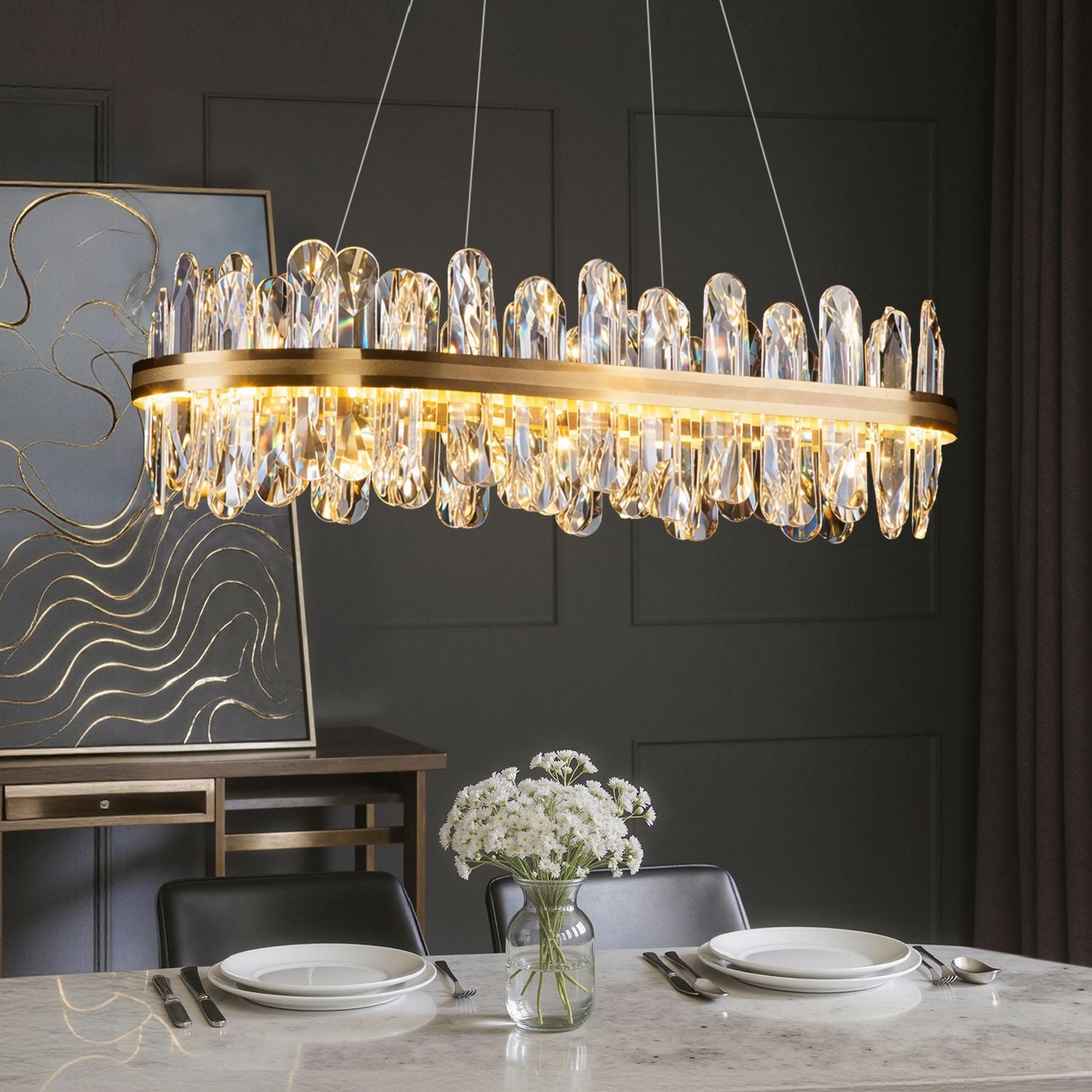 Aurelia Modern Luxury Champagne Gold Linear K9 Crystal LED Chandelier in a dining room — hanging above a marble dining table with white flowers, set with plates, glasses, and a minimalist backdrop | Sofary Lighting
