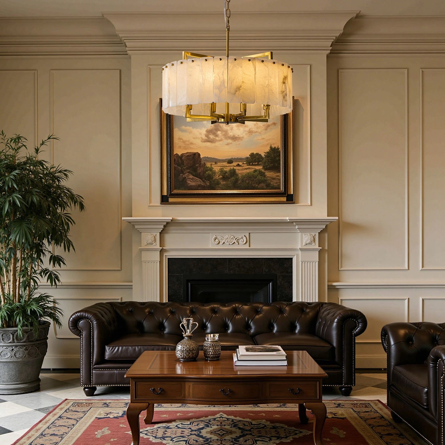 Round white alabaster chandelier with gold frame hanging in a formal neoclassical living room above a leather chesterfield sofa and marble fireplace. Sofary Lighting