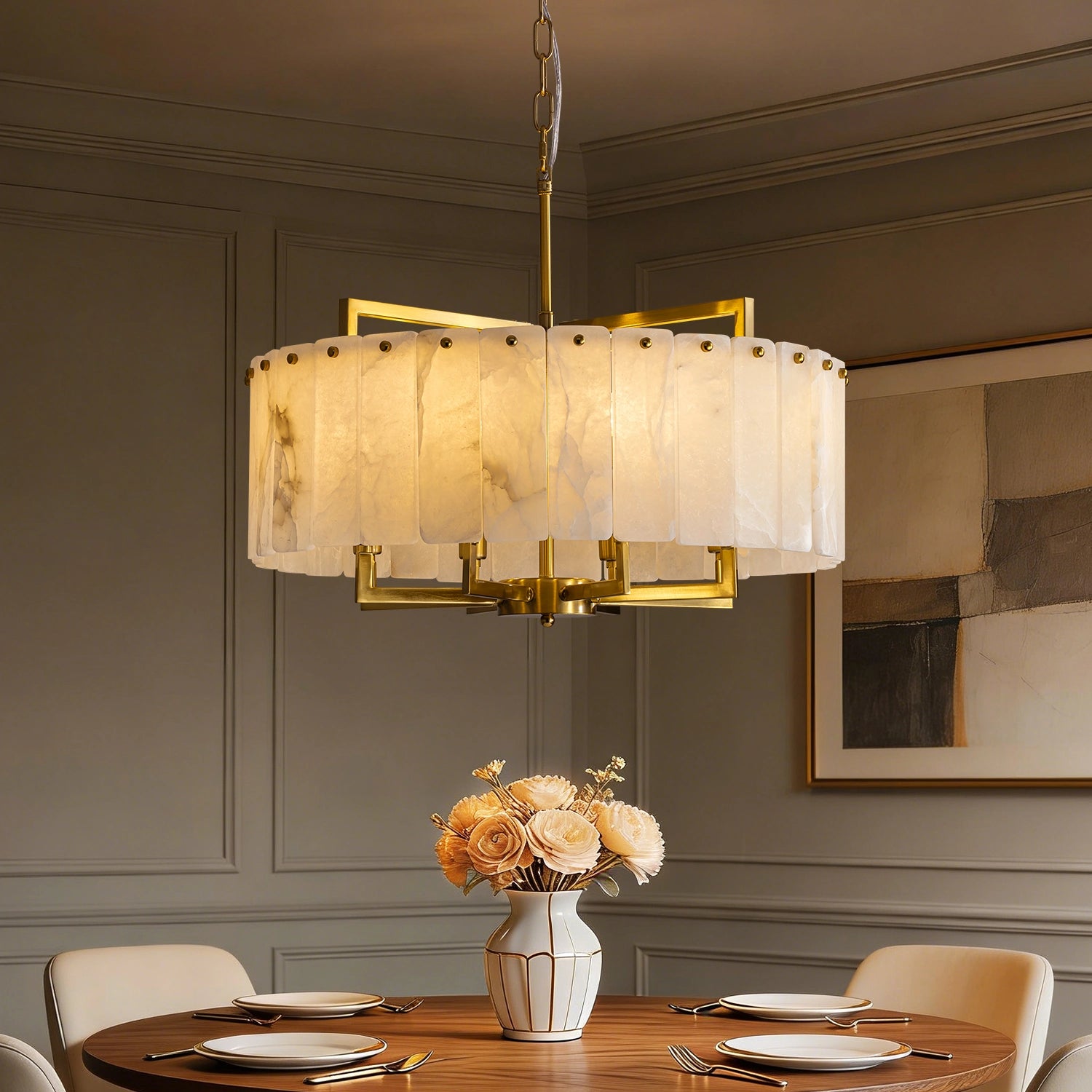 Modern round chandelier with natural white alabaster stone panels and gold brass frame hanging over a contemporary dining table. Sofary Lighting