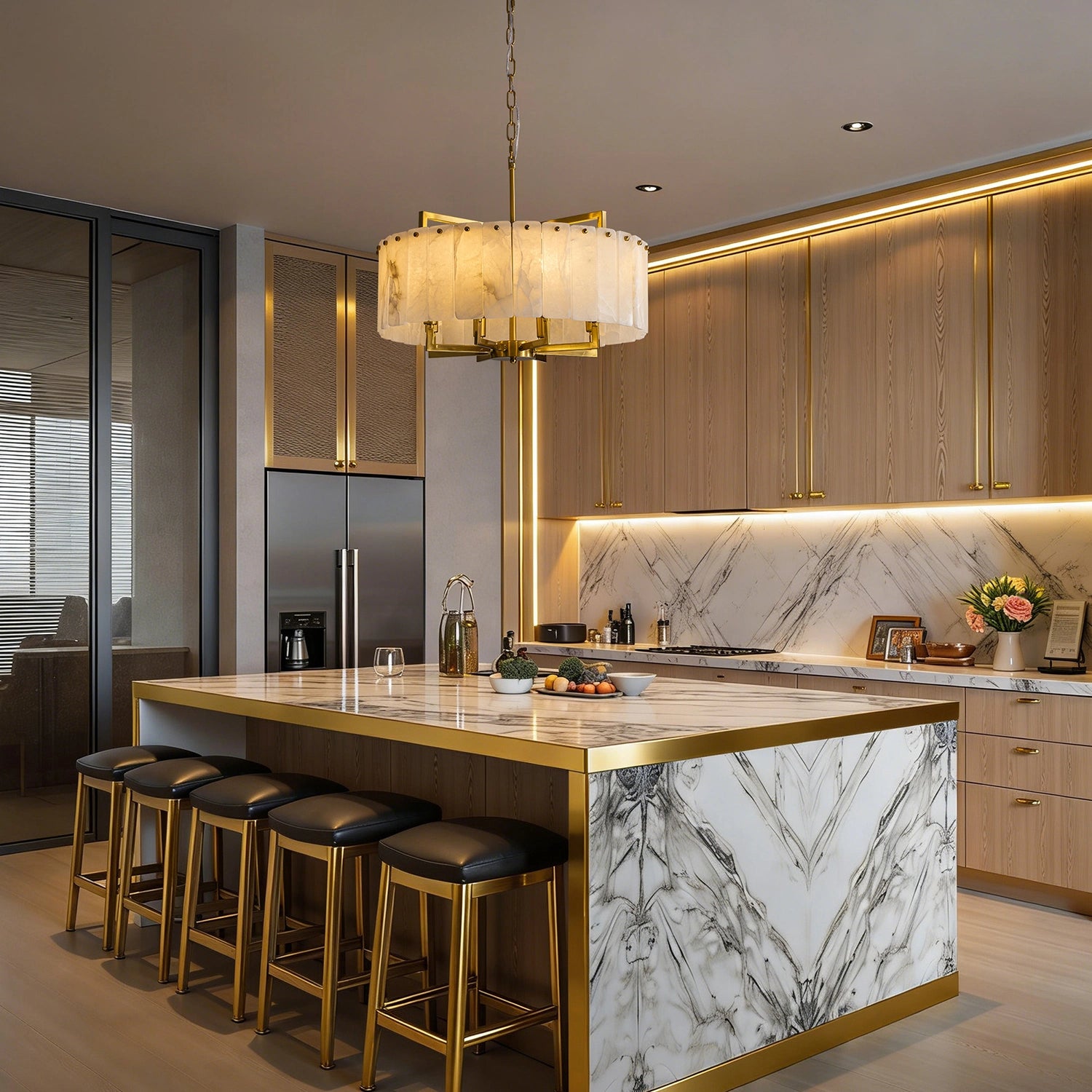 Large round alabaster stone chandelier with gold brass hardware hanging above a marble kitchen island in a contemporary open-concept home. Sofary Lighting