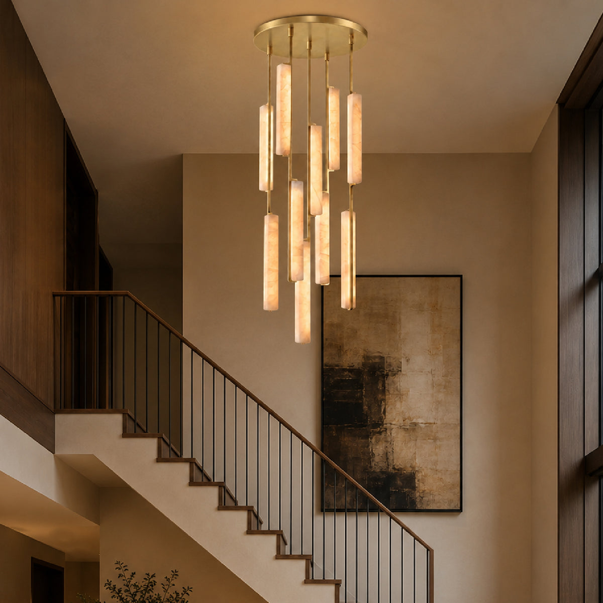 Stamen Modern Minimalist Alabaster Vertical Chandelier in a luxury stair hall — suspended within a double-height space beside an elegant staircase, with warm wood details, sculptural furnishings, and refined architectural finishes in the background.
