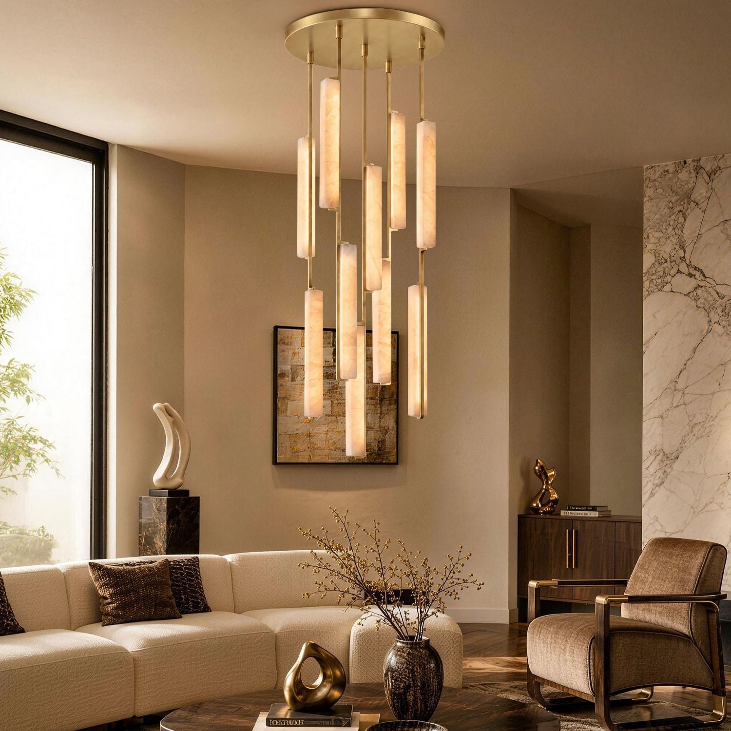Stamen Modern Minimalist Alabaster Vertical Chandelier in a luxurious living room — hanging above a beige sofa with decorative sculptures, a large abstract painting, and natural light from tall windows