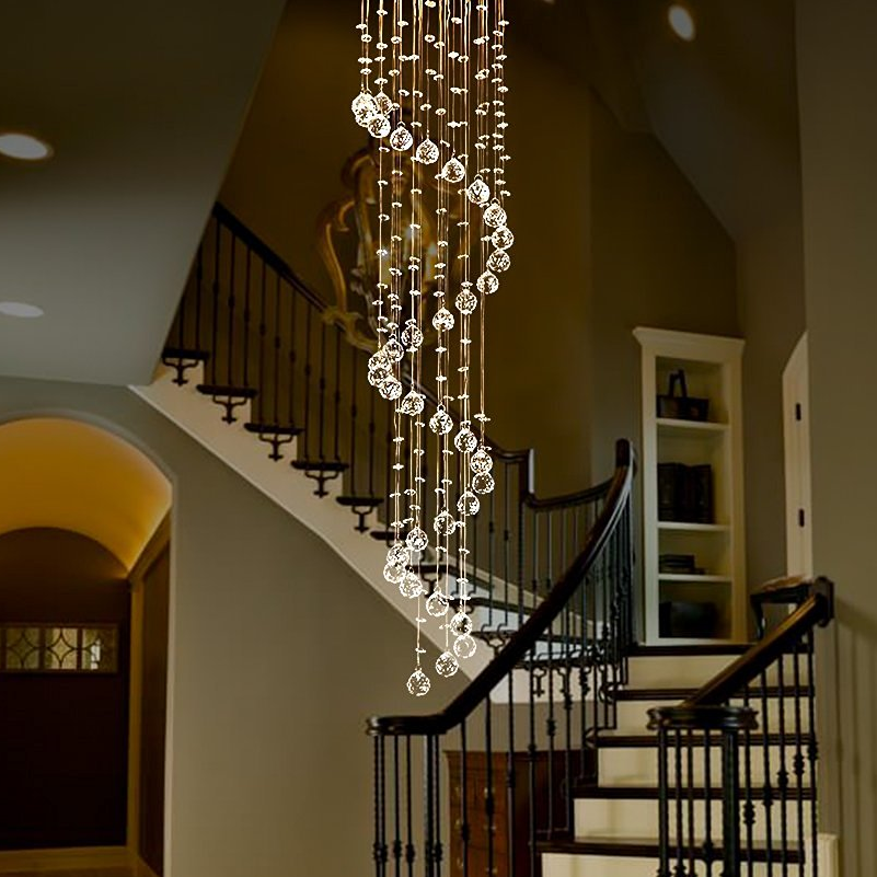 luxury k9 crystal spiral raindrop staircase chandelier installed above curved staircase in luxury home | Sofary Lighting