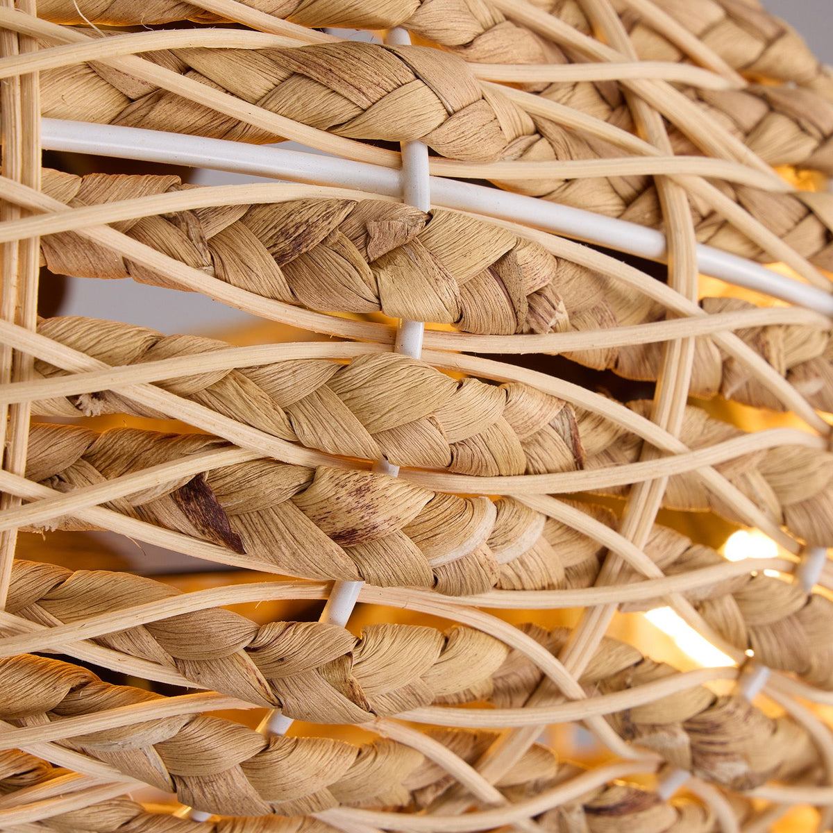 Close-up of boho rattan ceiling fan shade — natural hand-woven rattan texture, white frame structure, warm light glow, premium coastal craftsmanship | Sofary Lighting