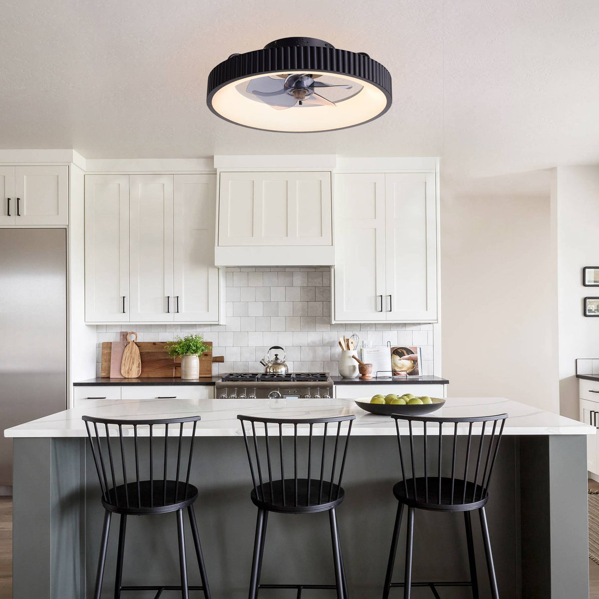 Ceiling fan with LED light over kitchen island — white cabinets, marble countertop, bar stools, modern kitchen, enclosed fan design