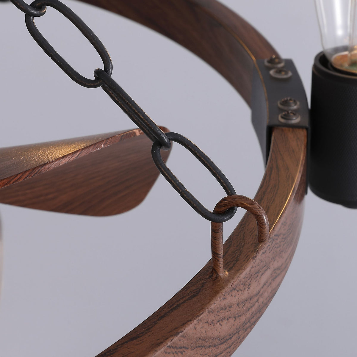 Close-up of wagon wheel fandelier — black chain link, rustic wood grain wheel, bulb socket, 28.3" farmhouse ceiling fan detail | Sofary Lighting