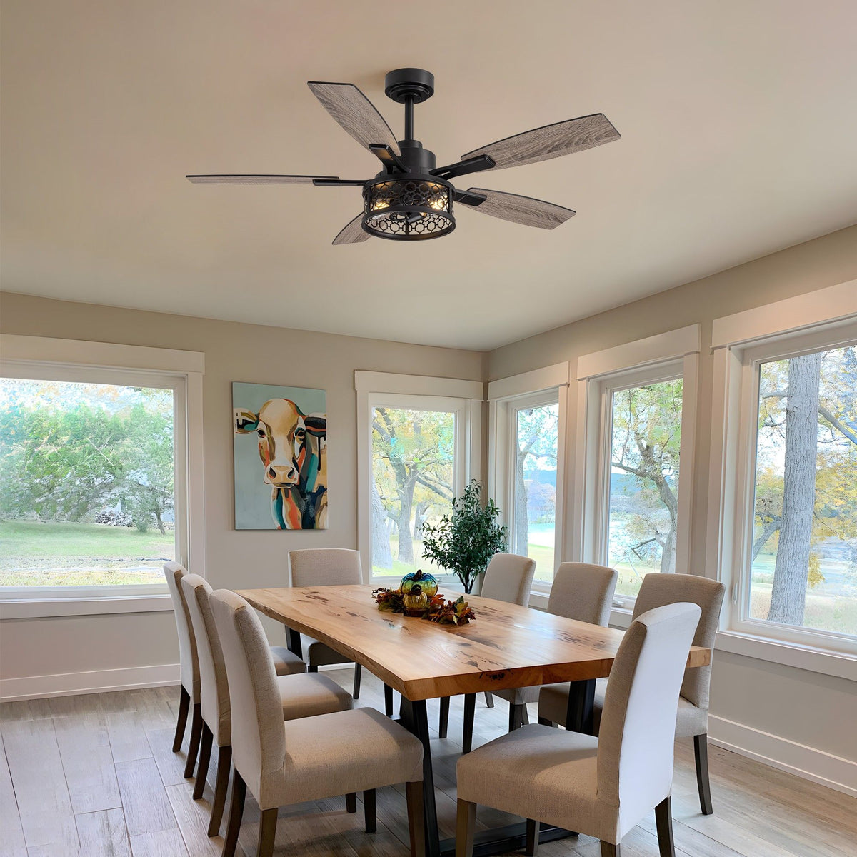 Farmhouse ceiling fan in dining room — wooden table, large windows, modern art, bright rustic space | Sofary Lighting