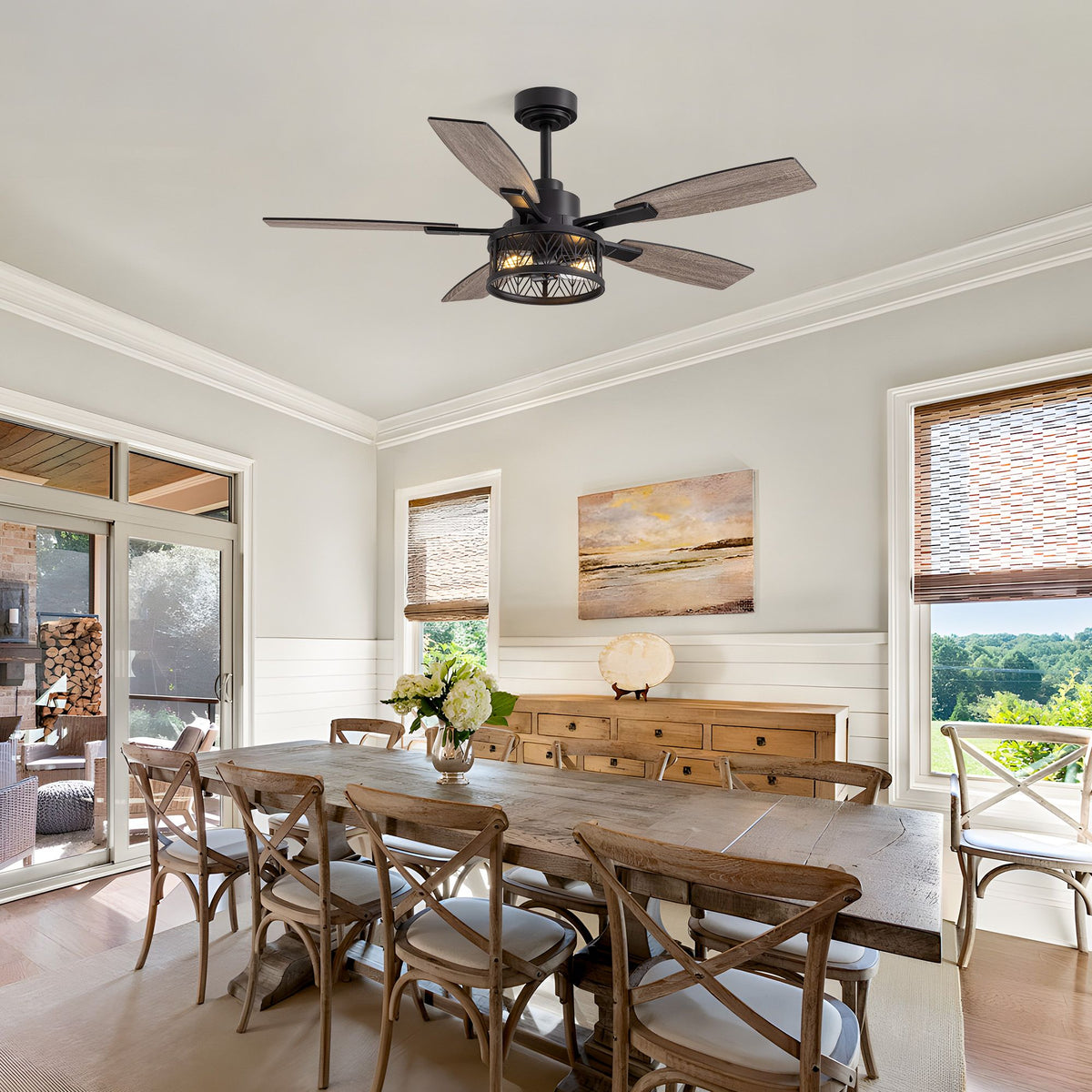 Farmhouse ceiling fan over dining area — long wood table, cross-back chairs, wicker shades, shiplap walls, outdoor view, rustic farmhouse style | Sofary Lighting