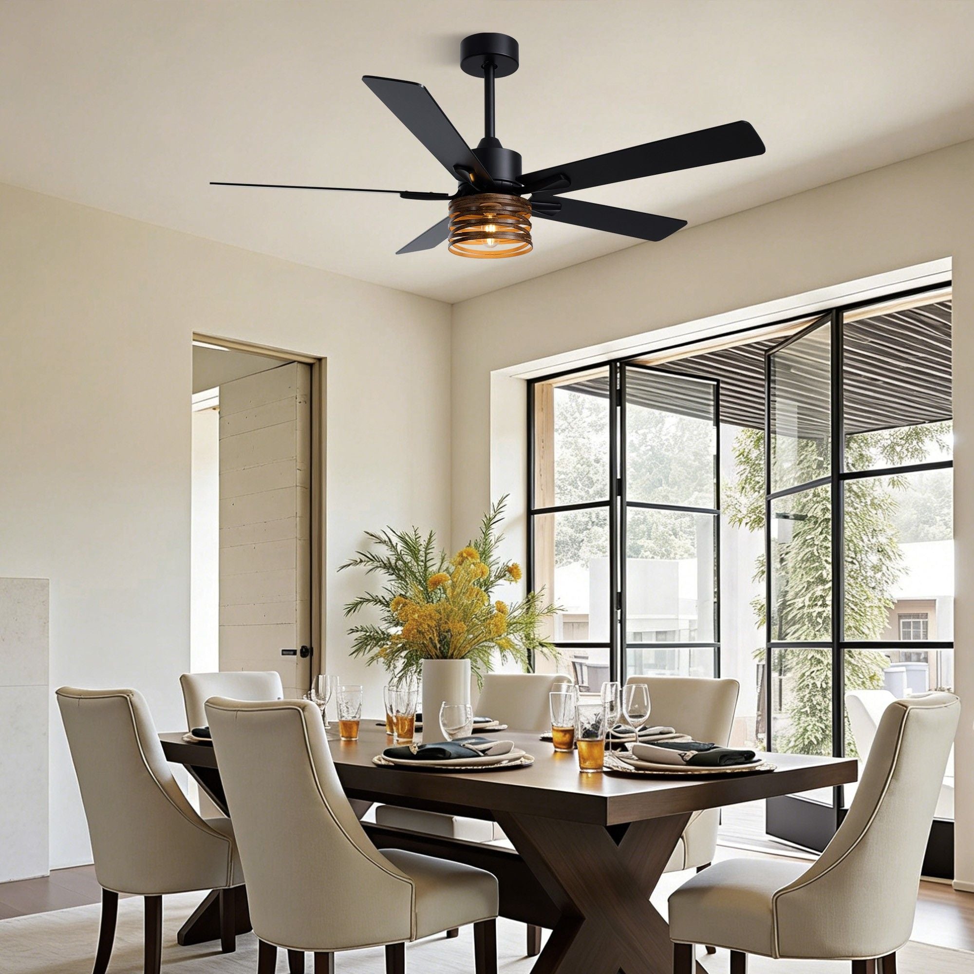 Industrial farmhouse ceiling fan in dining room — dark wood table, cream upholstered chairs, amber glass light shade, black frame folding glass doors, floral centerpiece | Sofary Lighting