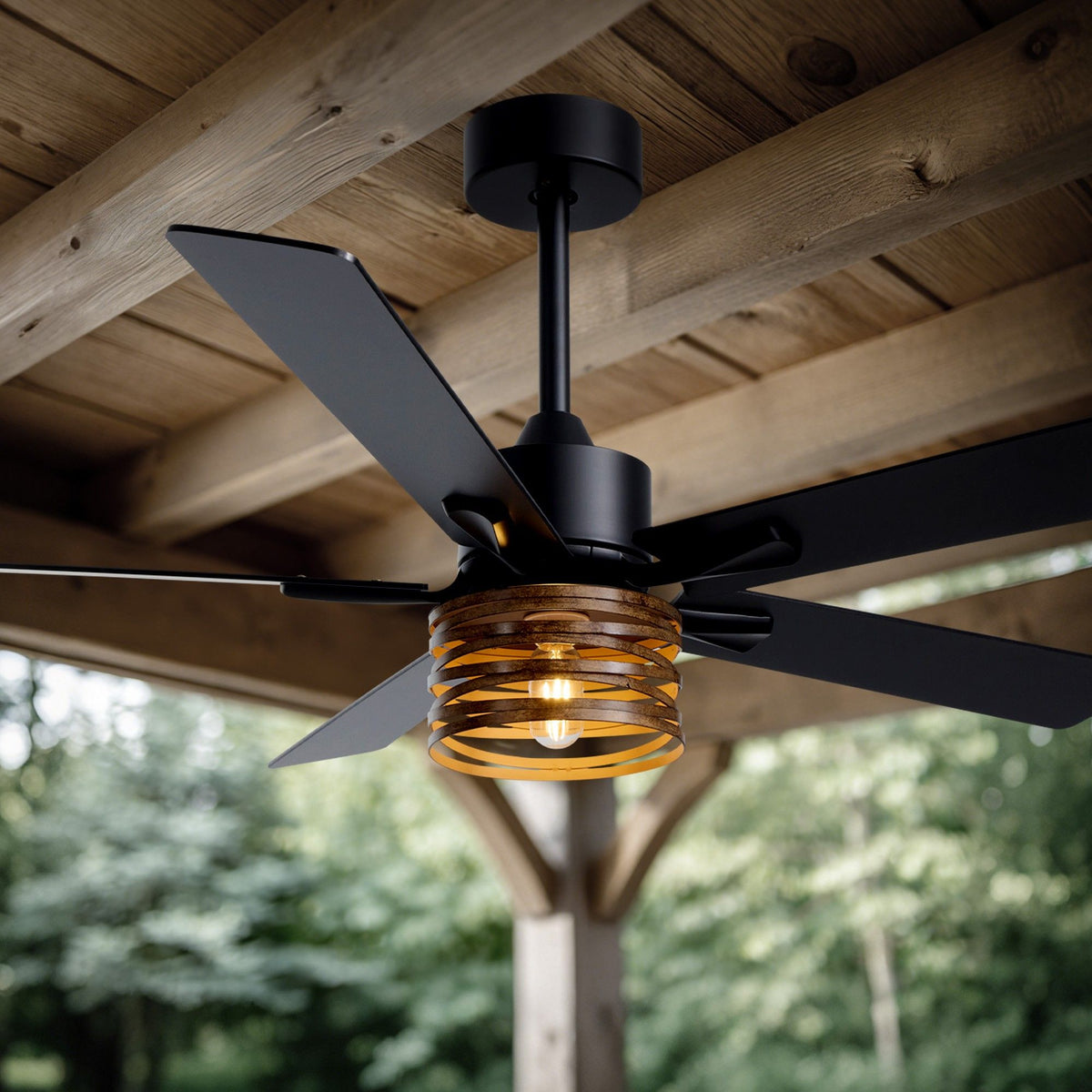 Industrial farmhouse ceiling fan outdoor patio — wood plank ceiling, black metal frame, amber glass light shade, lush green garden background, warm glow | Sofary Lighting