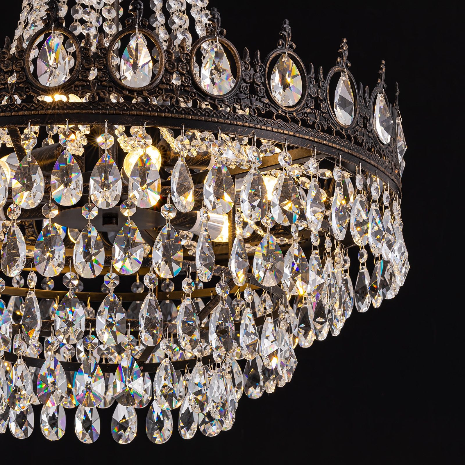 Aerian K9 crystal chandelier teardrop prisms — faceted light refraction, tiered draping, warm bulb glow, premium crystal strands against dark background | Sofary Lighting