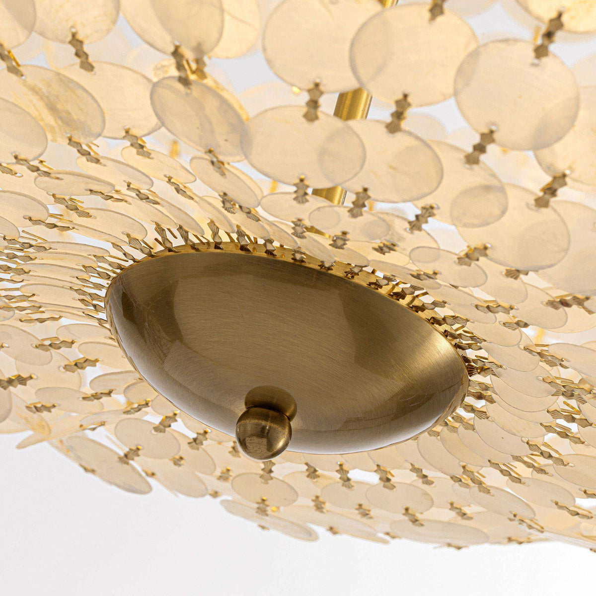 Close-up of Aeroh Chandelier bottom/canopy — brushed gold oval canopy, chain connection, inner shell disc layers, warm illuminated interior | Sofary Lighting