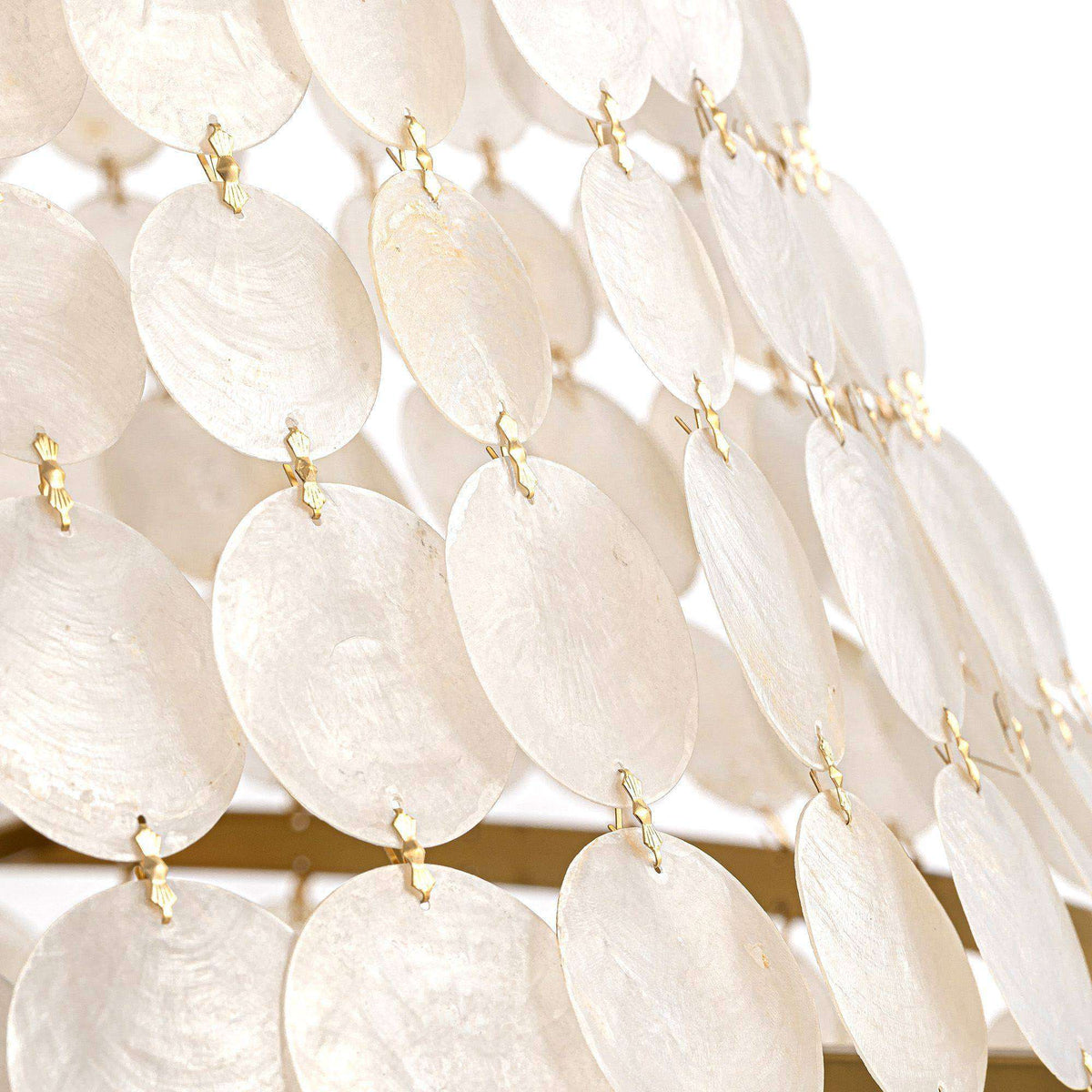 Close-up of Aeroh Shell Pendant texture — natural white shell/pearl discs, gold hooks and links, layered cascading design, light refraction, black background | Sofary Lighting