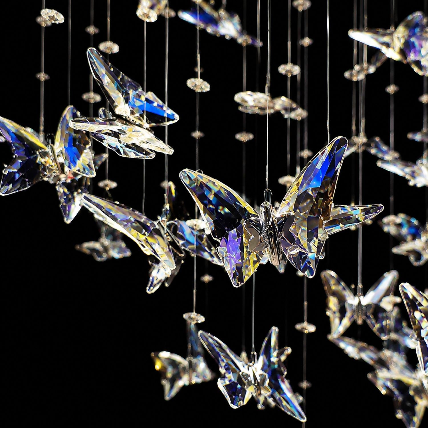 Close-up of Aerosi Linear Chandelier — iridescent K9 crystal butterflies, gold-tone metal body, light refraction, black background highlighting premium craftsmanship | Sofary Lighting
