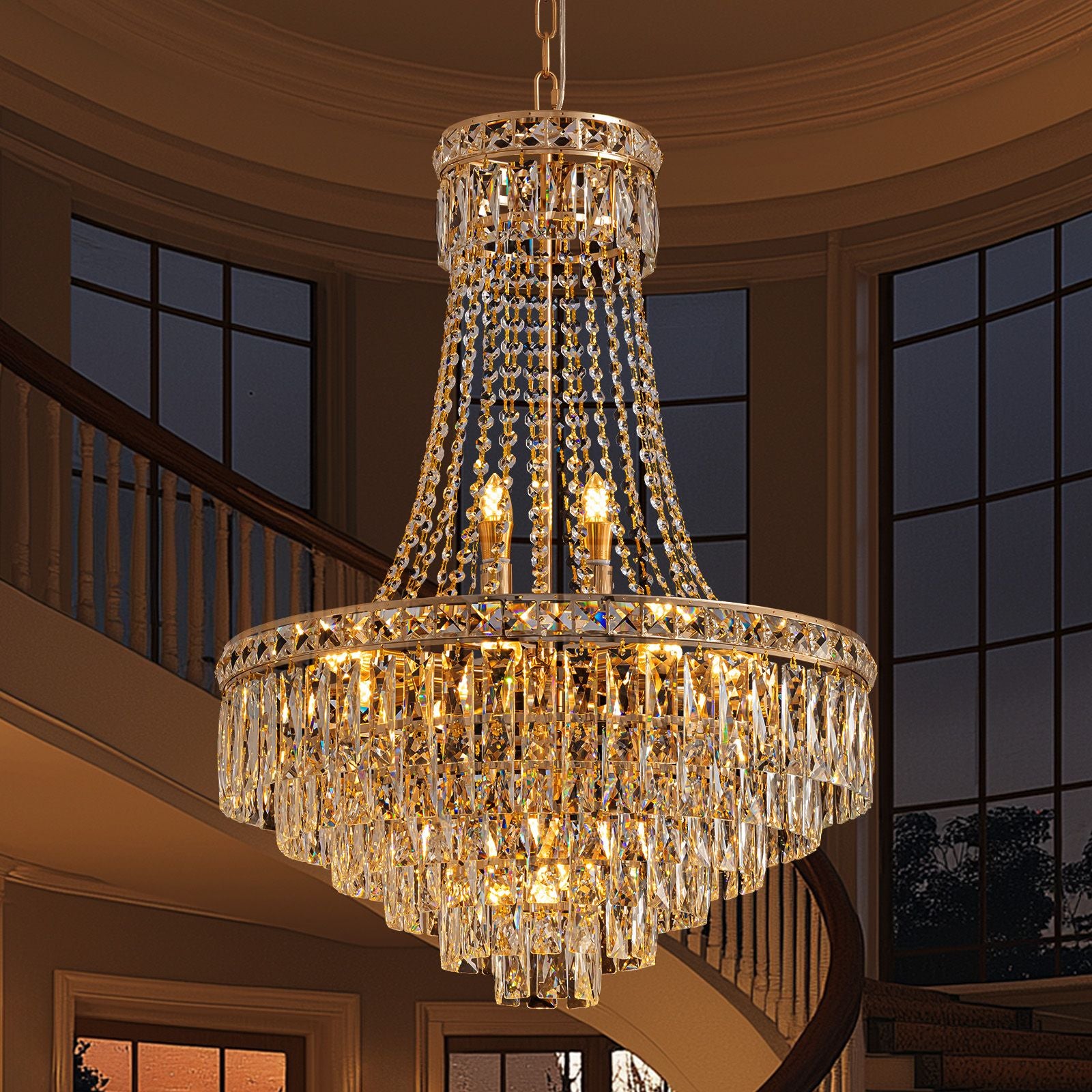 Aerova K9 crystal chandelier glowing in modern staircase — double-height foyer, glass railings, natural light, elegant vertical illumination for luxury homes
