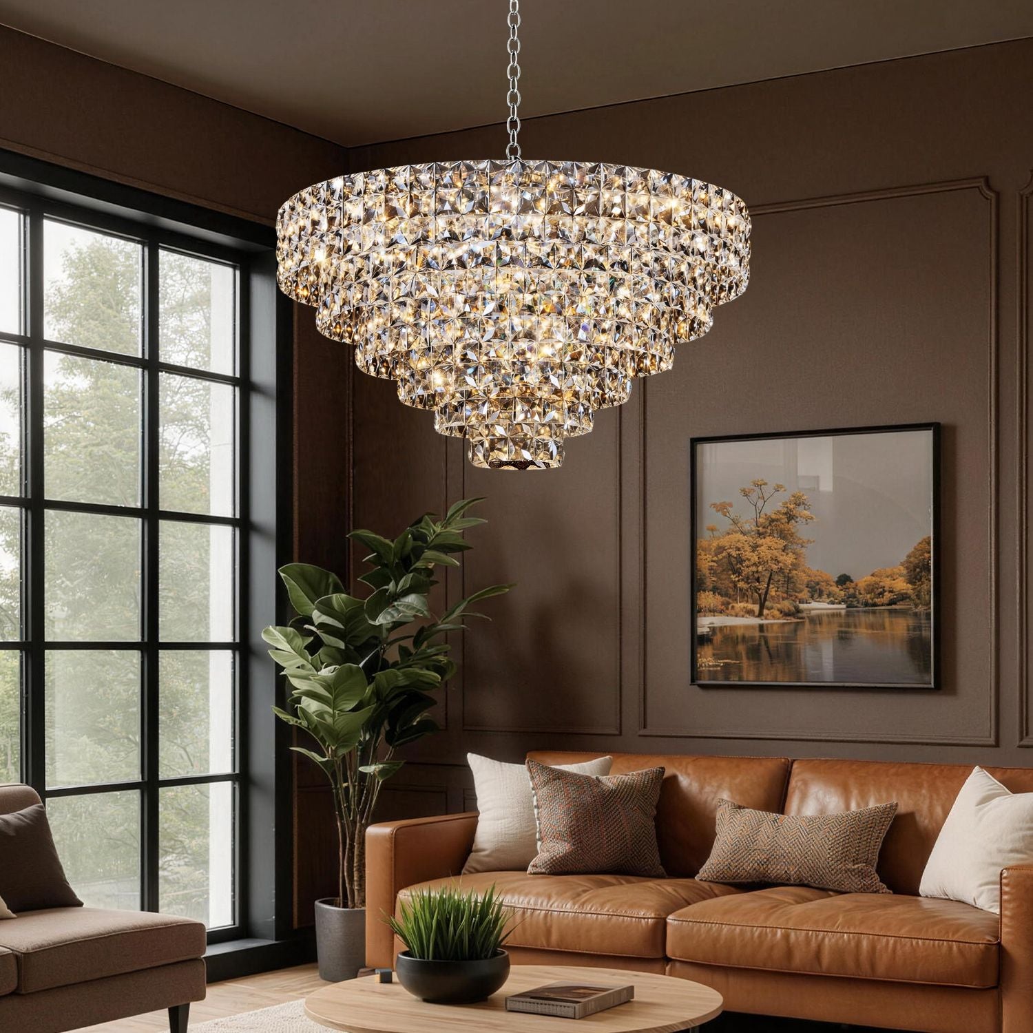 Aria Modern Gold K9 Crystal Glacier Chandelier in a cozy living room — casting layered, ambient light over a tan leather sofa, large windows, and lush greenery for modern luxury | Sofary Lighting
