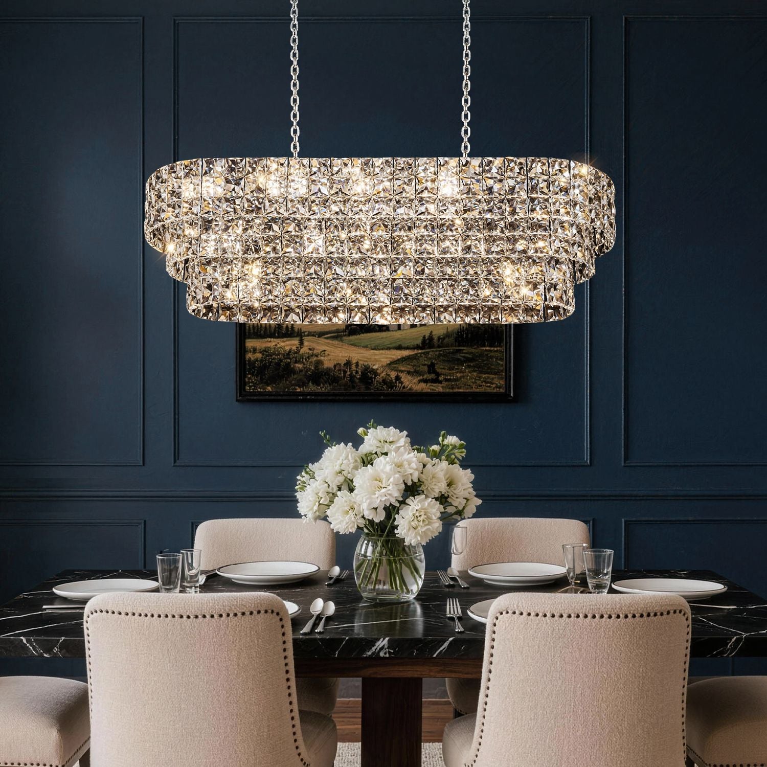 Aria Post-Modern Champagne Gold K9 Crystal Linear Three-Color Dimming Chandelier enhances a cozy living room with a brown leather sofa, large grid windows, lush green plants, and autumnal wall art | Sofary Lighting