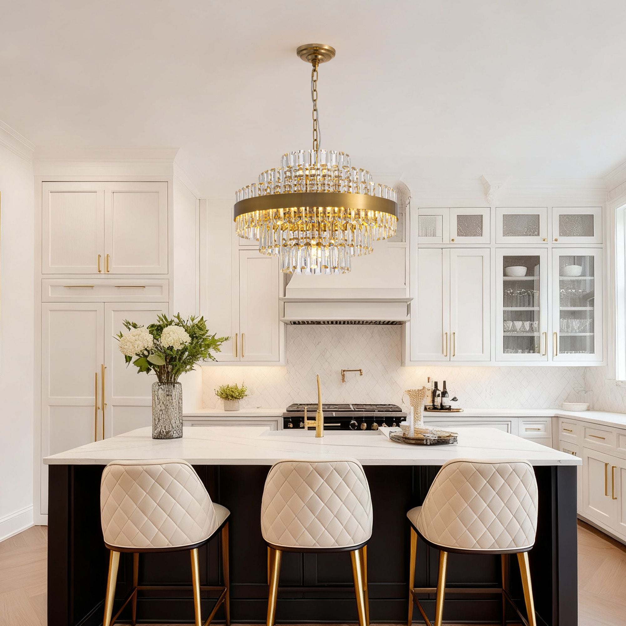 Aureole Round Raindrop Chandelier over white kitchen island — gold accents, quilted bar stools, bright modern luxury kitchen lighting | Sofary Lighting