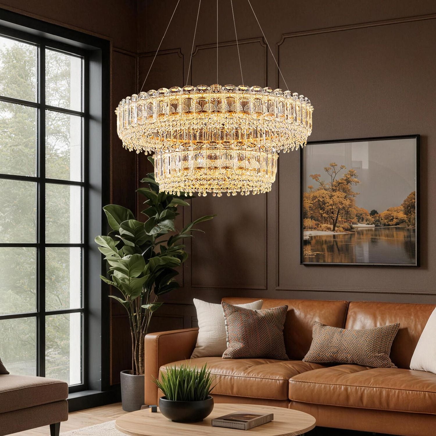 Empire Modern Luxury Gold K9 Crystal Double Tiered Three-Color Dimming Chandelier elevates a cozy living room with layered, eye-catching illumination, complementing a leather sofa, large windows, and autumnal artwork