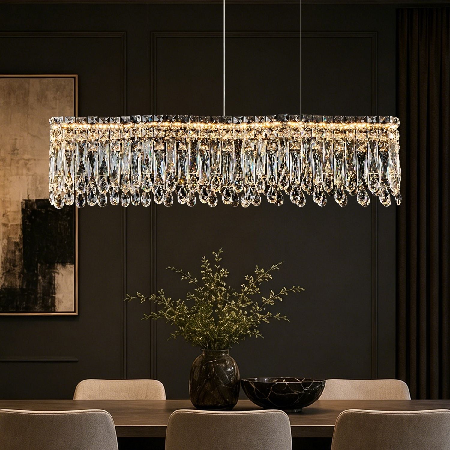 Flow Linear Modern Wave Integrated LED K9 Crystal Dining Chandelier in a dining room — hanging above a dark wooden table with blue and white flowers, elegant tableware, and a black paneled wall backdrop | Sofary Lighting