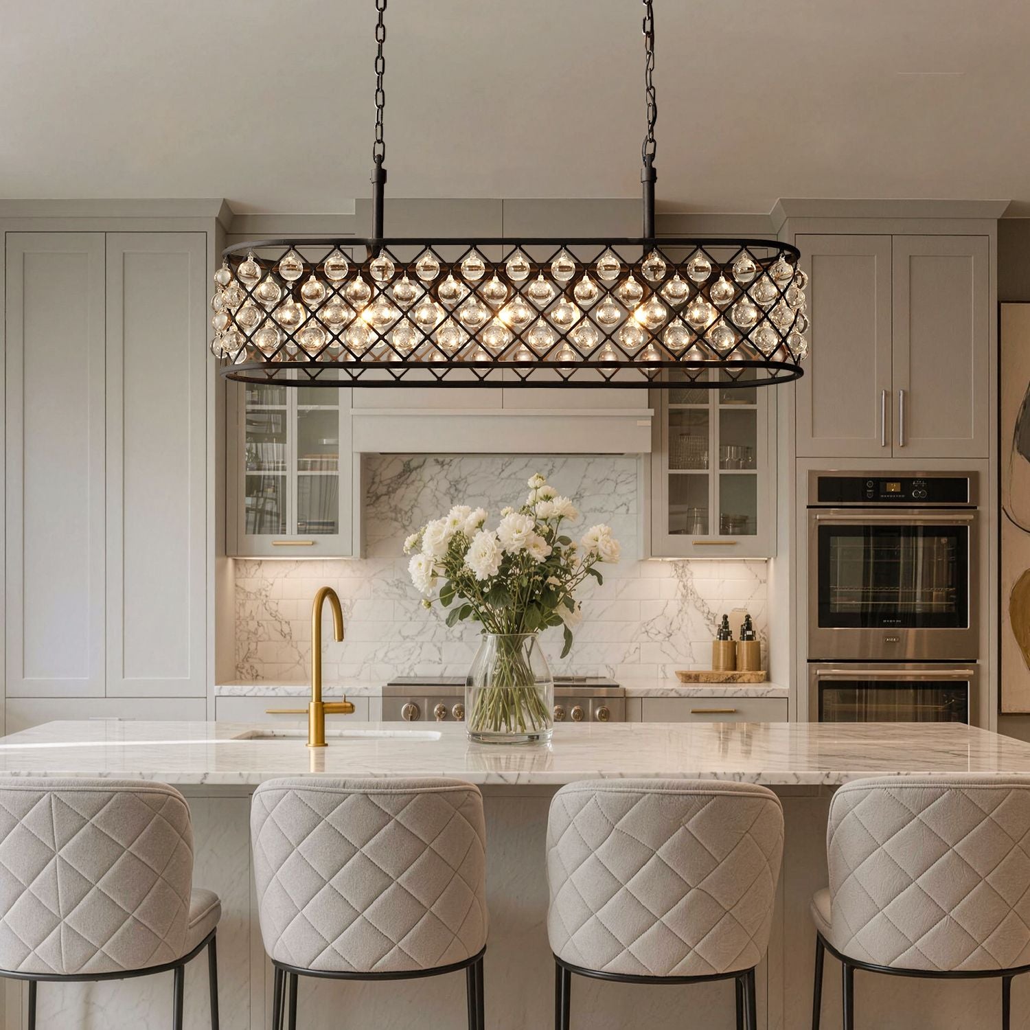 Harlow Modern Industrial Matte Black K9 Crystal Rectangle Chandelier in a kitchen island — hanging above a marble countertop with bar stools, a vase of white flowers, and modern kitchen appliances | Sofary Lighting
