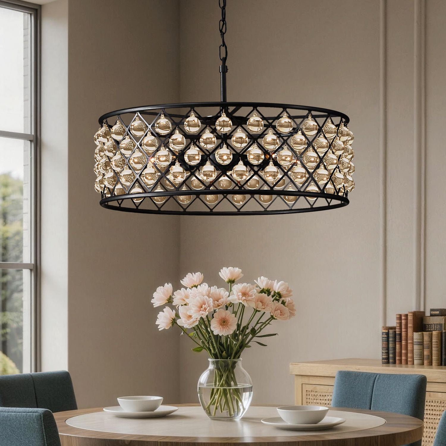 Harlow Vintage Matte Black K9 Crystal Round Chandelier in a dining room — hanging above a round table with a vase of pink flowers, elegant tableware, and a bright window backdrop | Sofary Lighting