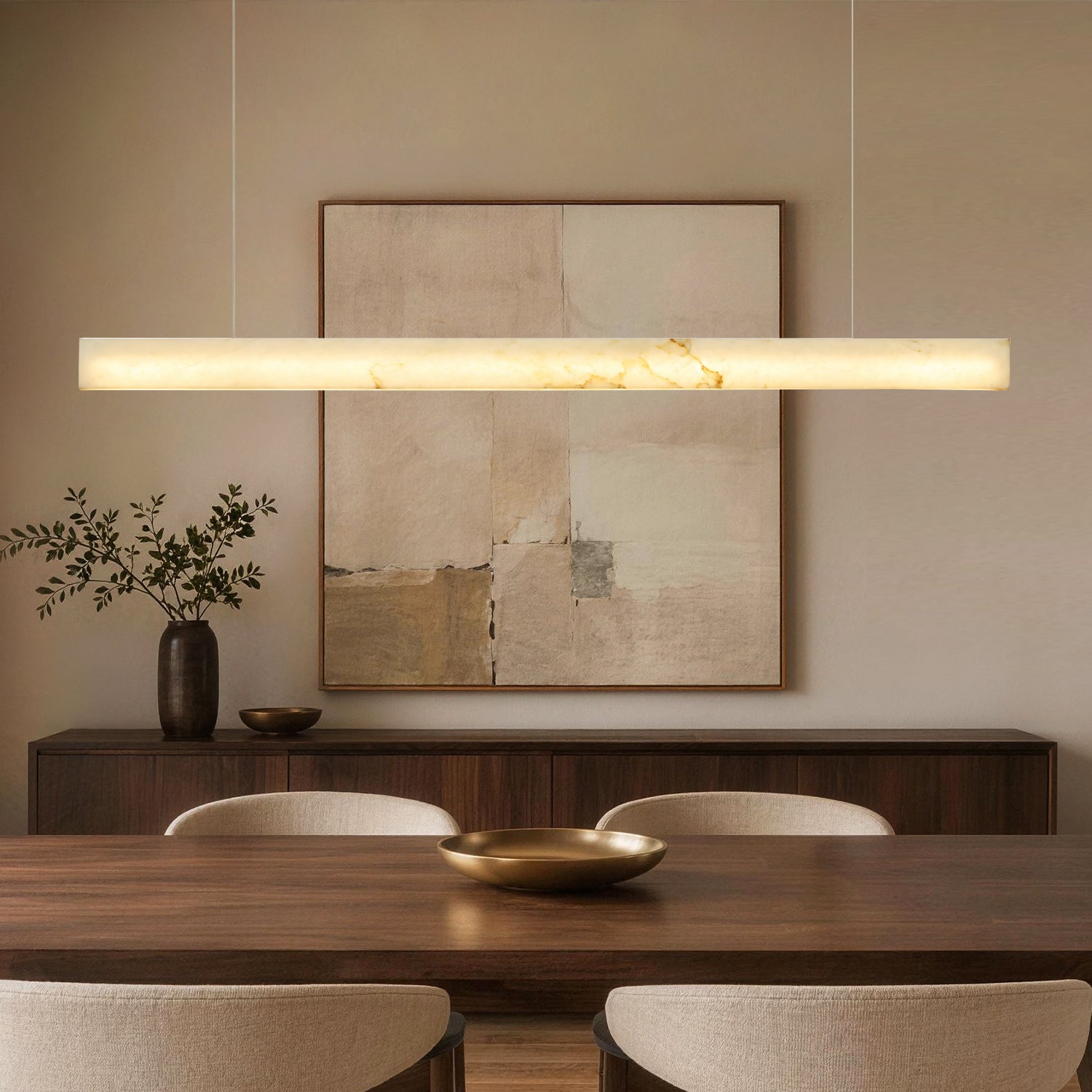 Horizon Modern Minimalist Alabaster Ultra-Slim Linear LED Chandelier in a dining room — suspended above a wooden dining table with a black bowl centerpiece, dark wood cabinet, and abstract wall art in the background | Sofary Lighting
