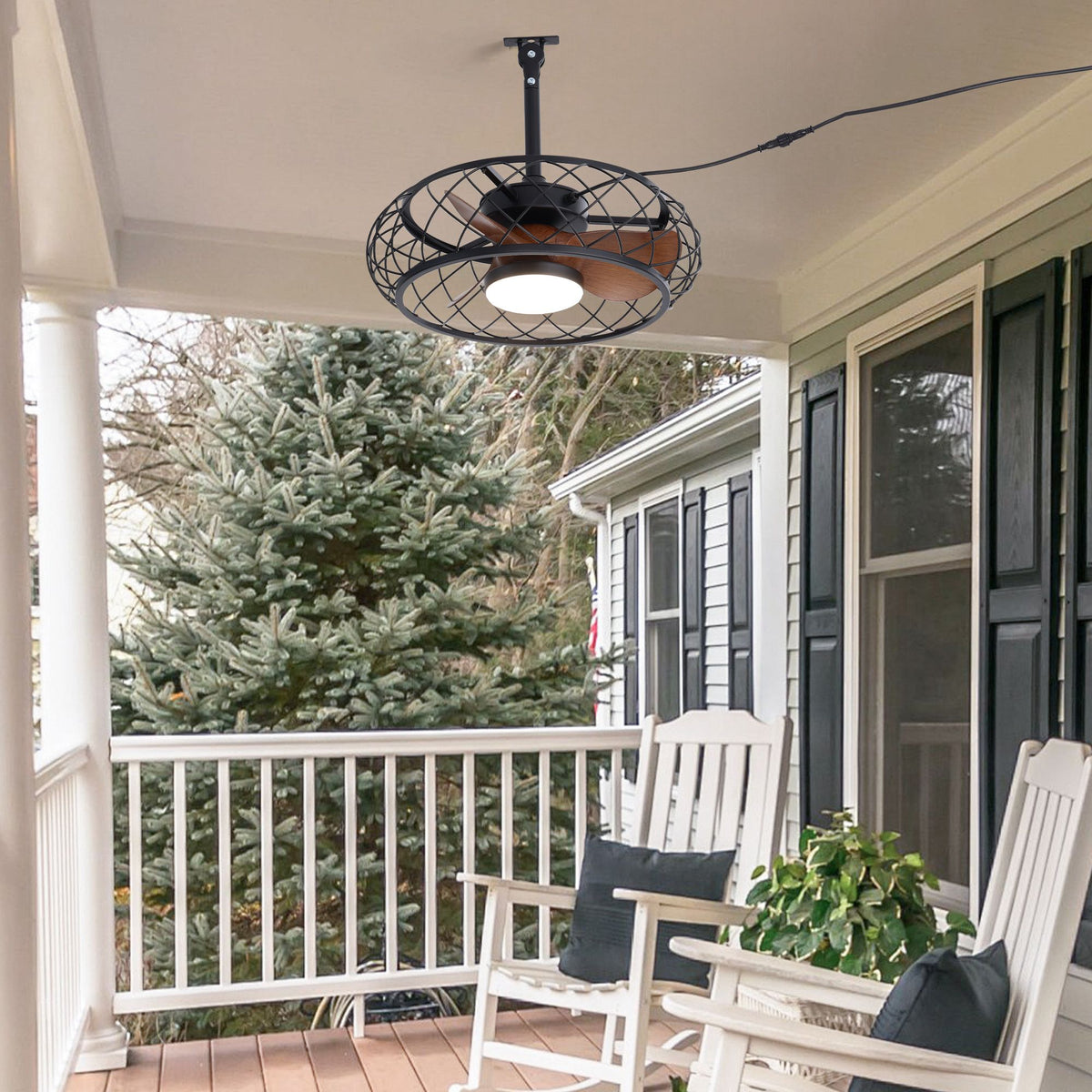 Outdoor ceiling fan on front porch — white railing, rocking chairs, evergreen tree, black caged fan, plug-in design, cozy porch decor | Sofary Lighting