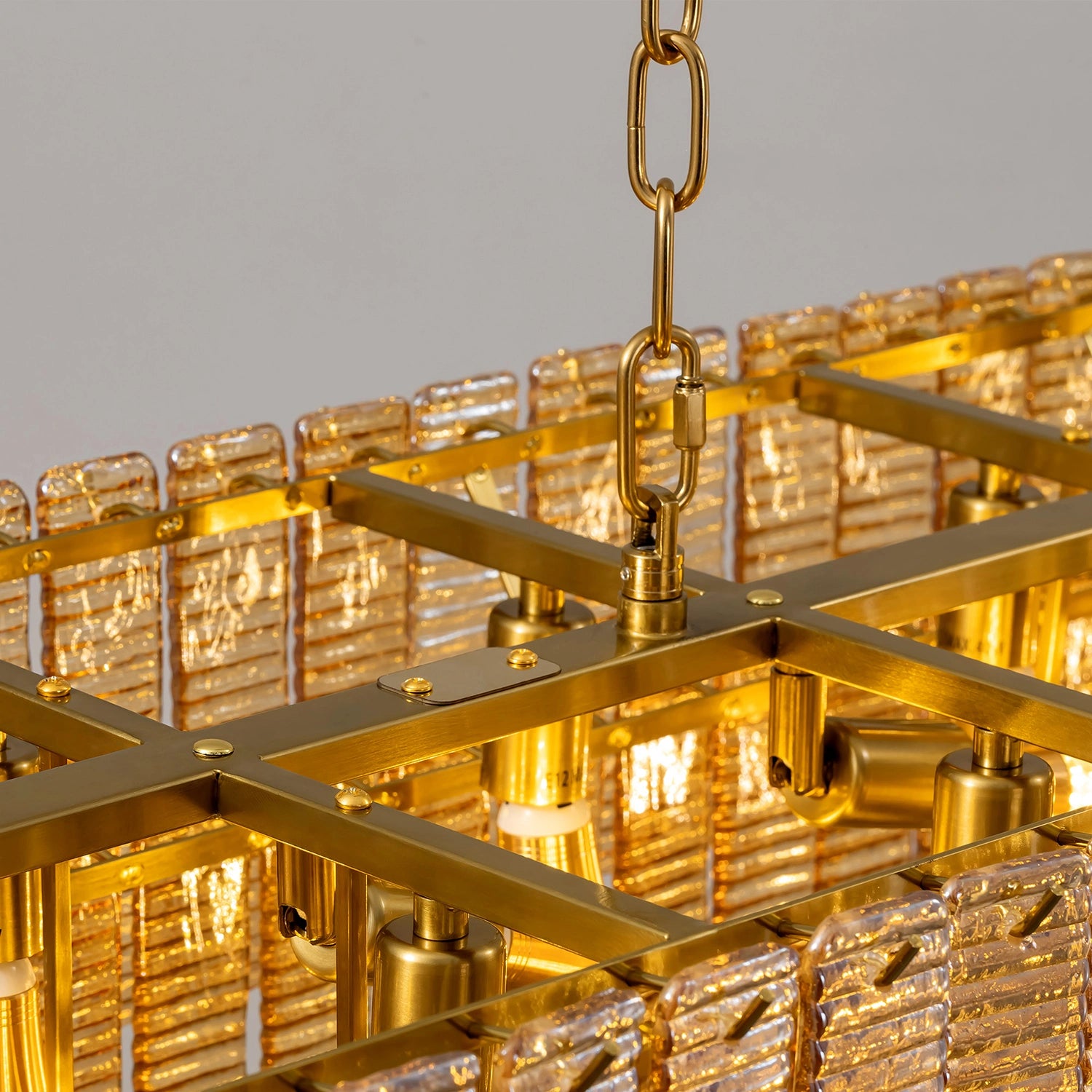 Close-up of the internal gold metal frame and E12 bulb sockets of the tiered amber glass chandelier, showing durable construction and gold finish. Sofary Lighting