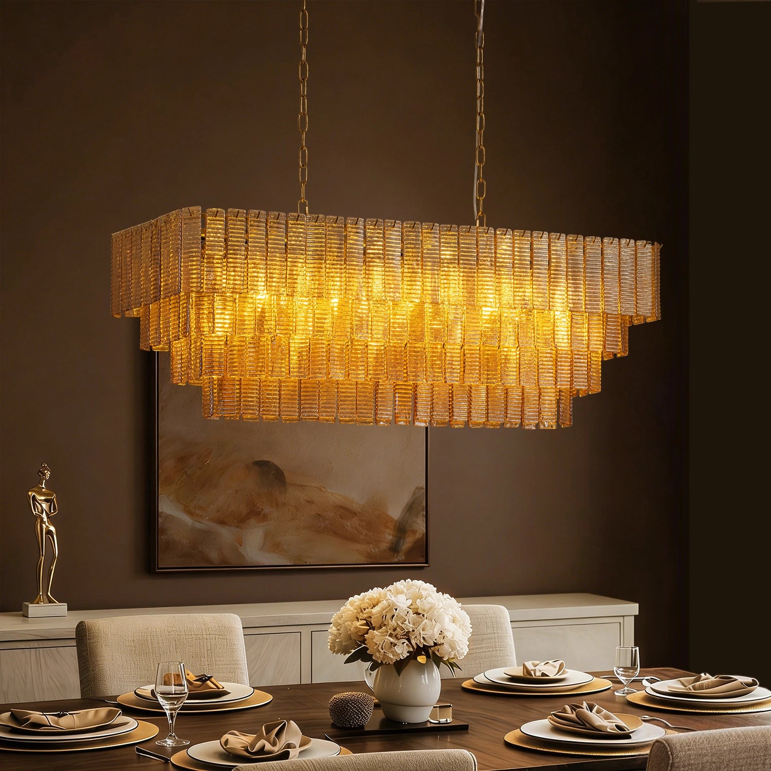 Modern rectangular tiered amber glass chandelier with gold finish hanging over a formal dining table Sofary Lighting